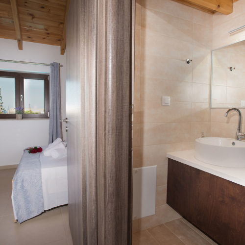 A bright maisonette interior with a bedroom on one side and a modern bathroom vanity on the other
