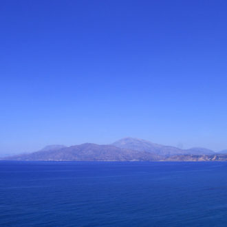 Wide blue sea with distant mountains under a clear sky along the South Crete coast