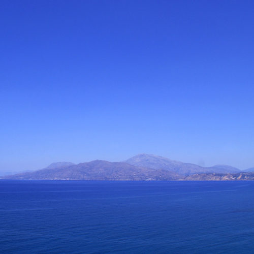 Wide blue sea with distant mountains under a clear sky along the South Crete coast