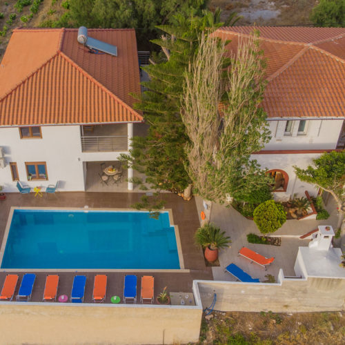 Aerial view of Houmeli Apartments in Kalamaki Crete with a pool, sun loungers, and landscaped courtyard
