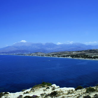 Wide coastal view of Kommos beach with deep blue sea and distant mountains
