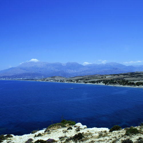 Wide coastal view of Kommos beach with deep blue sea and distant mountains