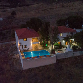 Aerial night view of Houmeli Apartments in Kalamaki Crete, with the pool and courtyard softly lit